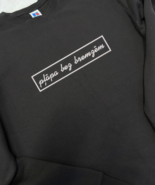 Teksta izšuvuma detaļa uz unisex apģērba