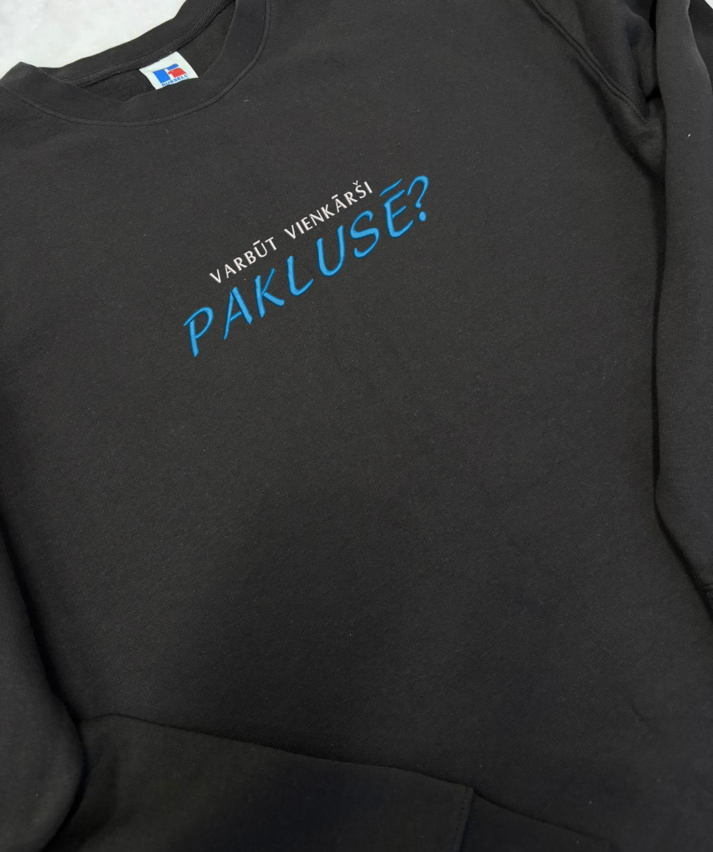 Izšūts teksts “Varbūt vienkārši paklusē” uz apģērba