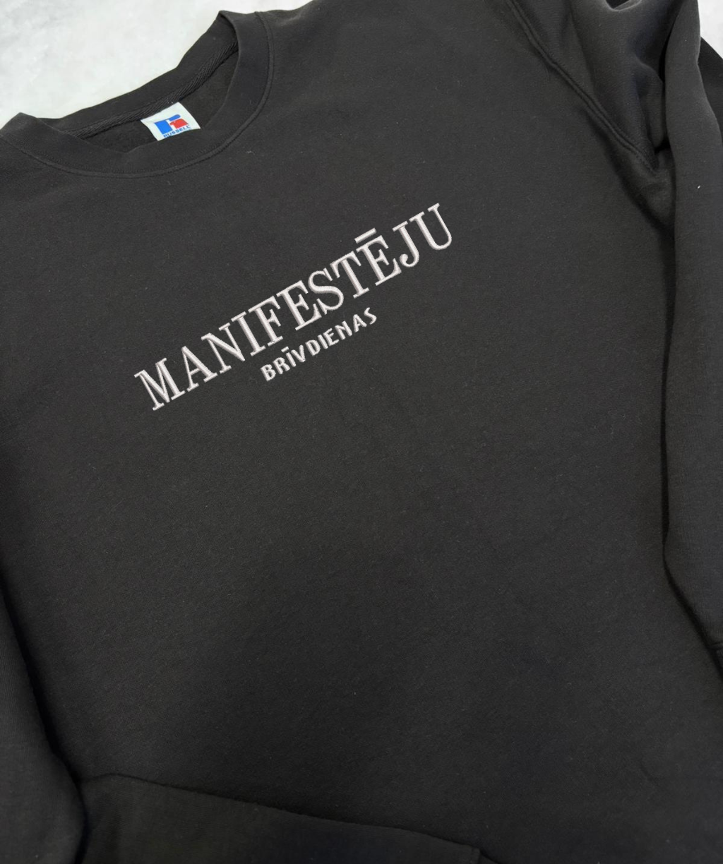 Teksta izšuvuma detaļa uz džempera